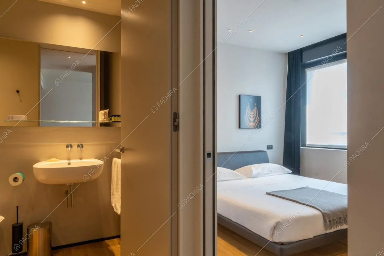 Dal bagno vista sulla camera da letto matrimoniale con pavimento in parquet