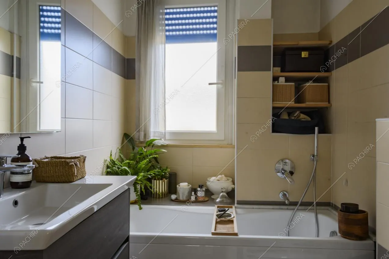 Bagno con vasca, lavandino, specchio e piccole mensole