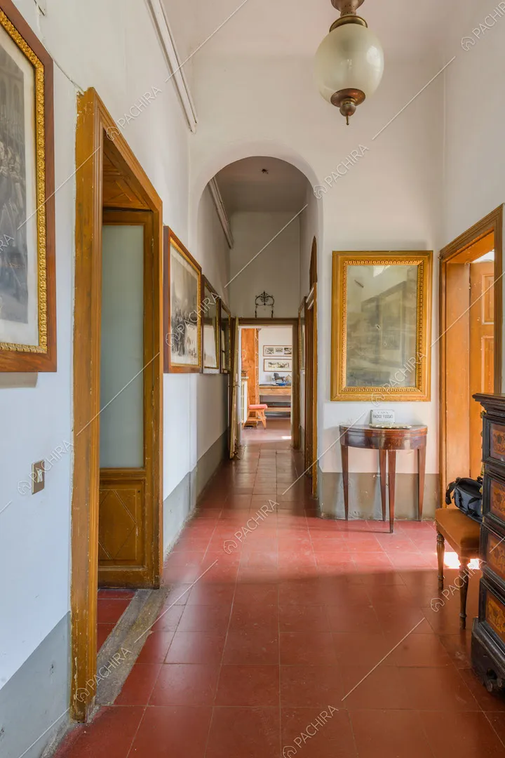 Grande corridoio con pavimento in piastrelle rosse e arco a tutto sesto