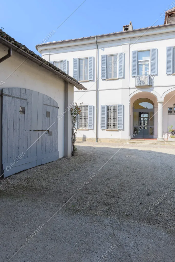 Pavimentazione in ciottoli nel cortile con vista sugli esterni bianchi della location