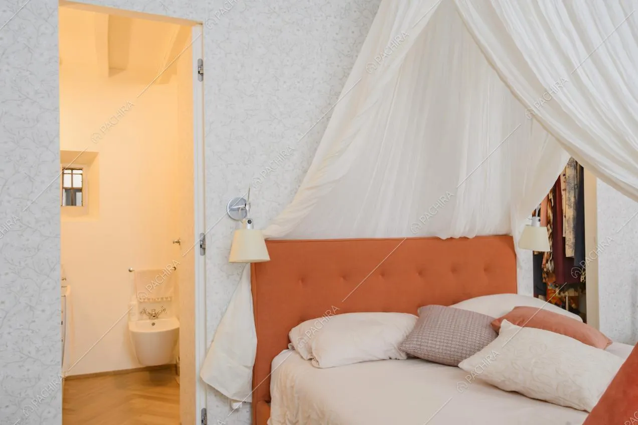 Camera da letto con bagno privato dalle travi a vista