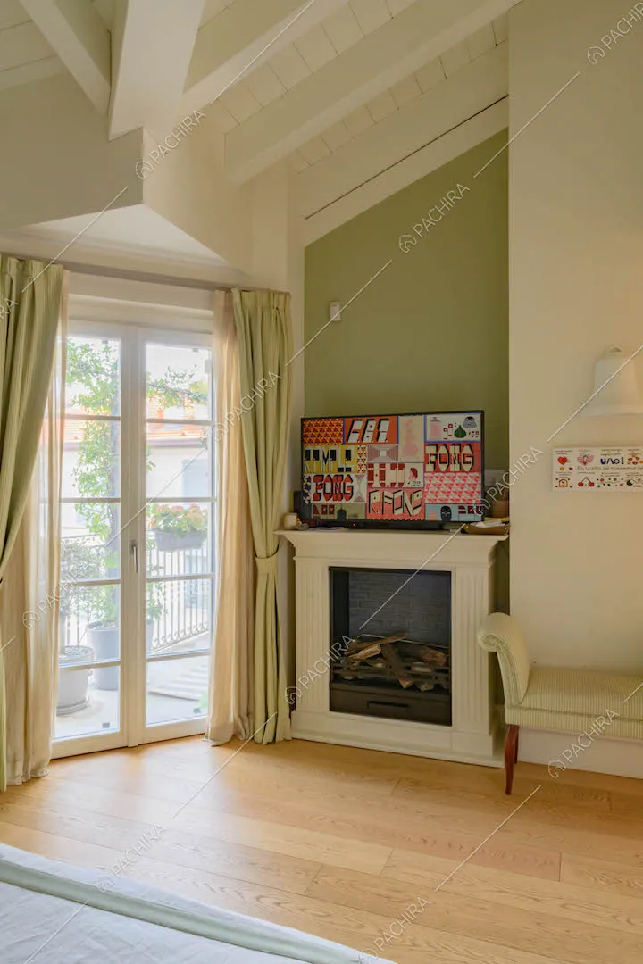 Luminosa camera da letto con porta-finestra, camino e pareti verdi e bianche