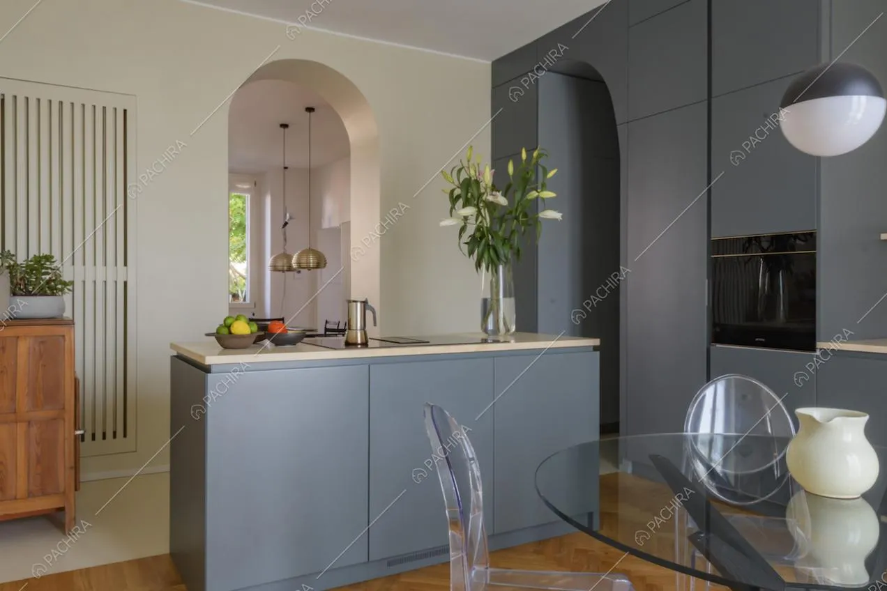 Cucina a isola con arredi grigi e tavolo tondo