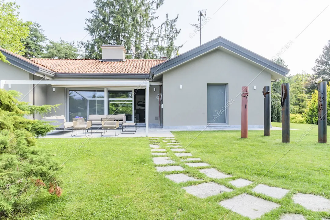 Vialetto d'accesso alla villa, zona conversazione e sculture nel giardino