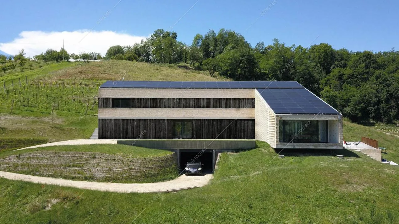 Vista sulla location immersa nel verde con garage e pannelli solari sul tetto