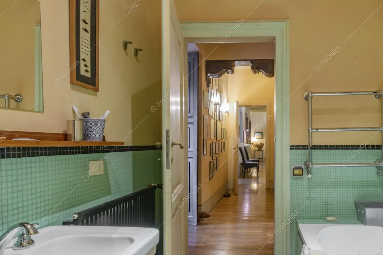 Bagno con parete color pastello e piastrelline in ceramica