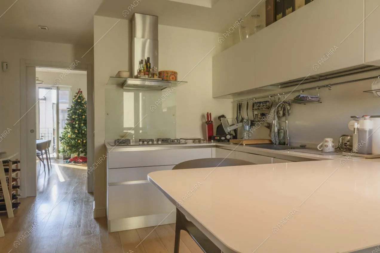 Cucina con bancone e sgabelli bianchi