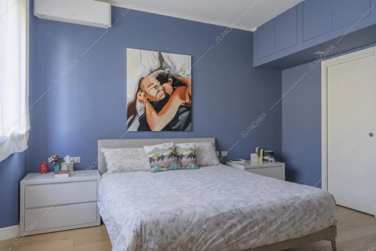 Camera da letto matrimoniale con pavimenti in parquet e comodini bianchi