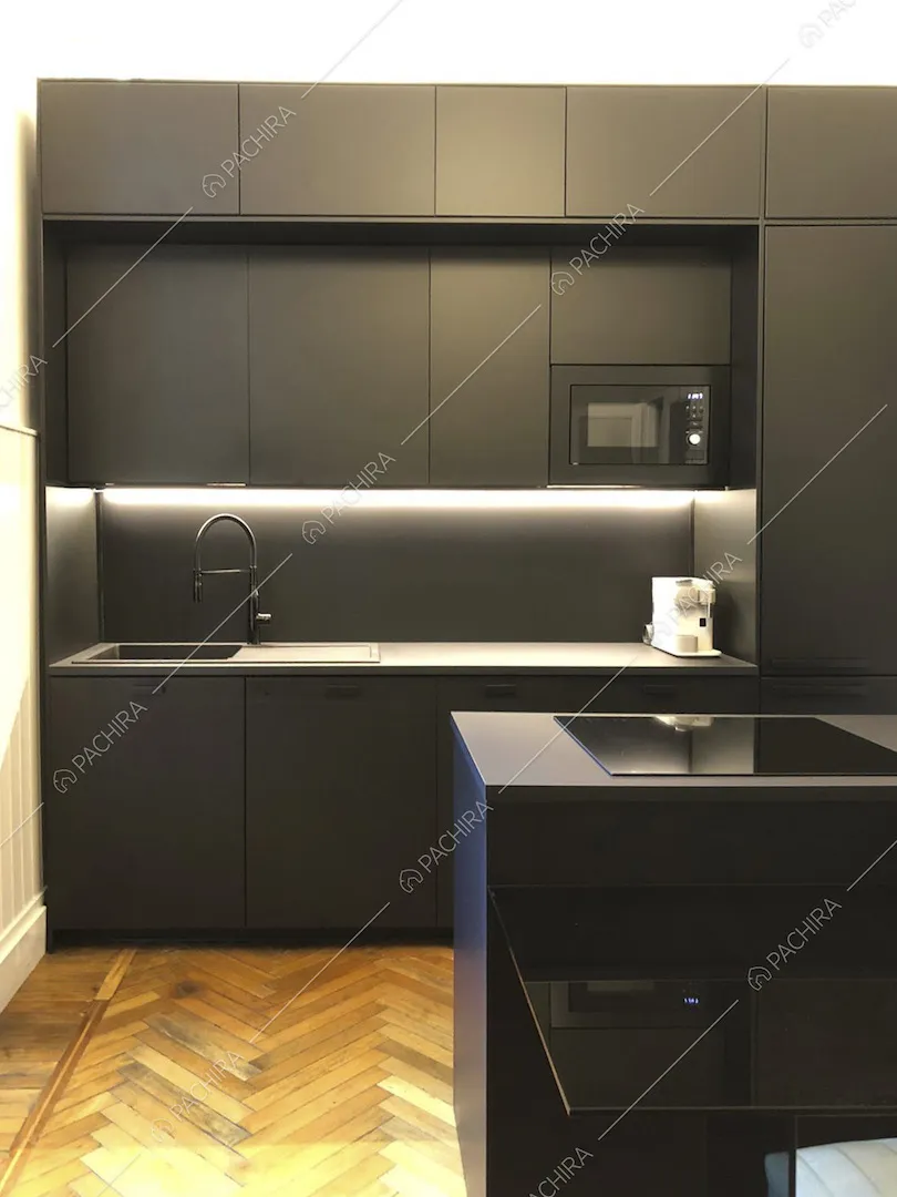 Cucina a parete nera e pavimento in parquet