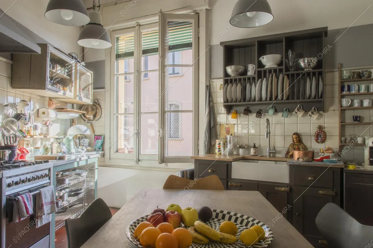 Cucina luminosa con arredi nei toni del grigio e ampia finestra