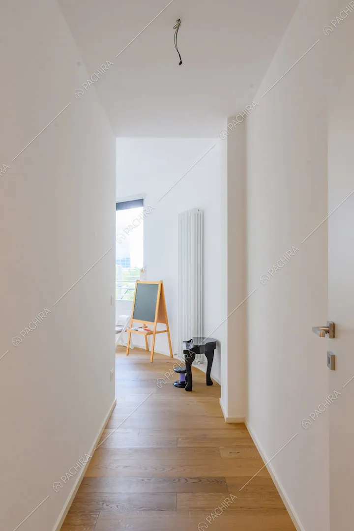 Luminoso corridoio con pavimento in parquet e pareti bianche
