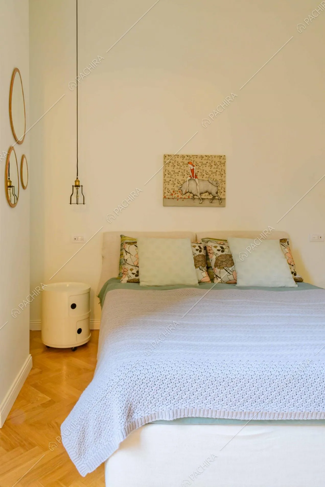 Camera da letto matrimoniale con pareti bianche e pavimento in parquet a spina di pesce