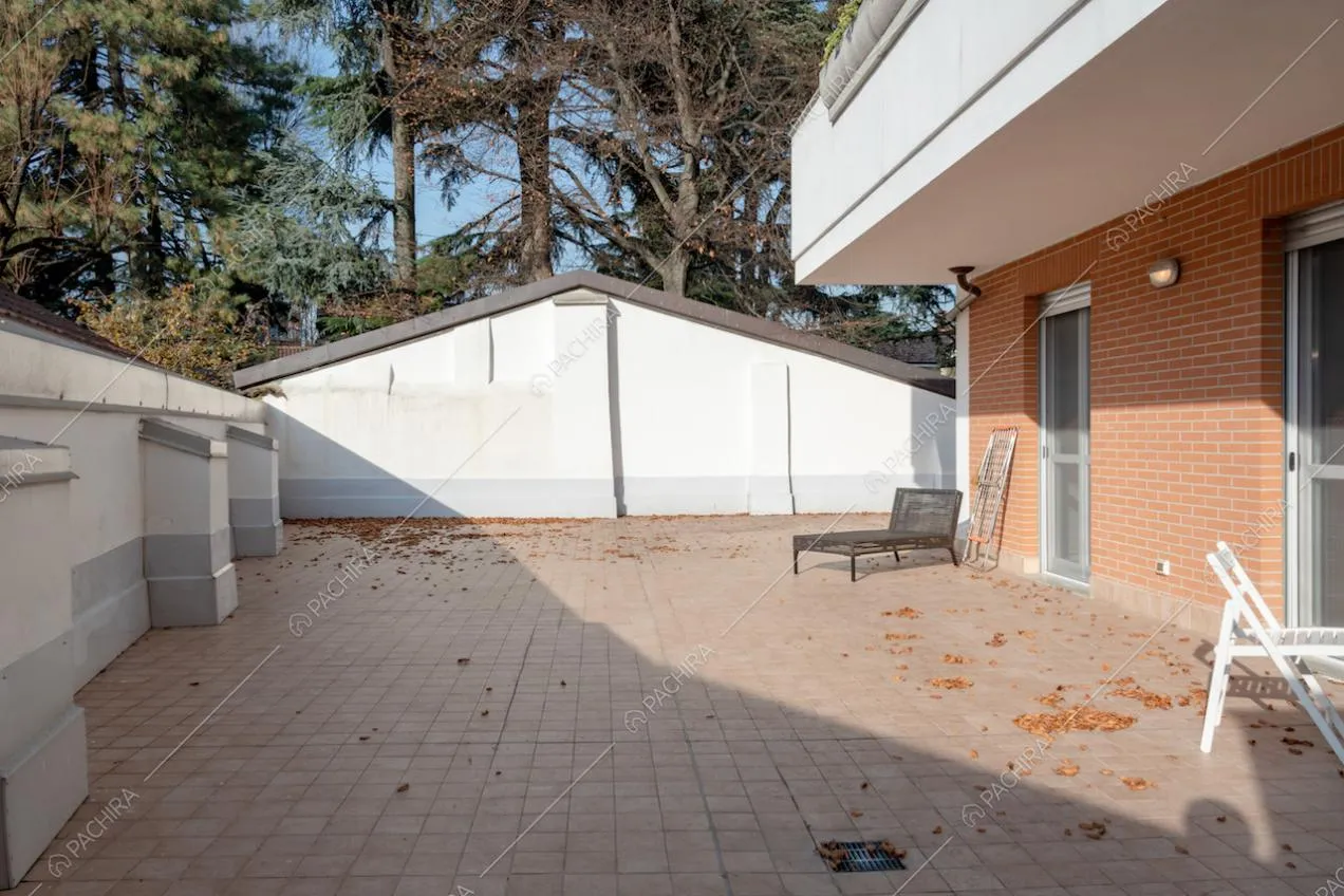 Grande terrazza soleggiata con sedie e sdraio