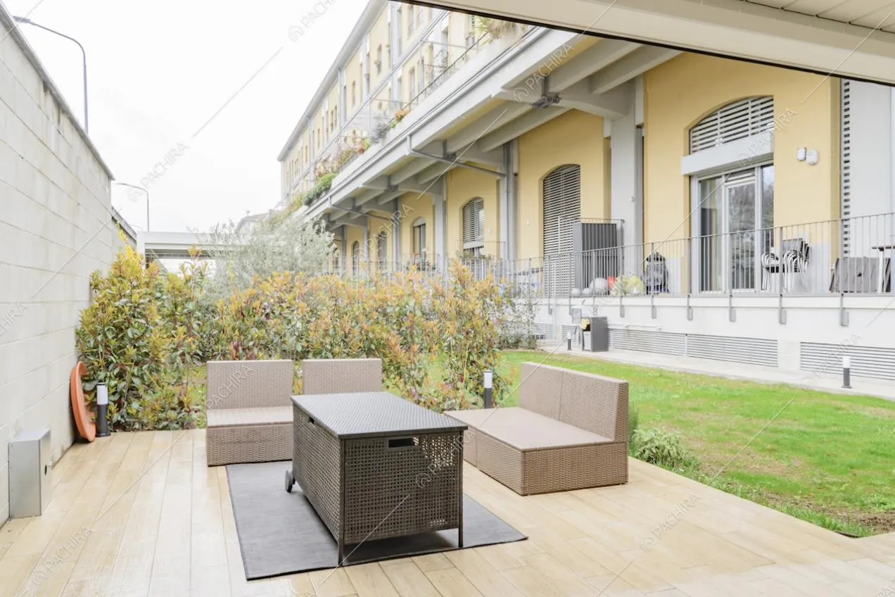 Salotto da esterni con pavimentazione in parquet e vista sul balcone della location