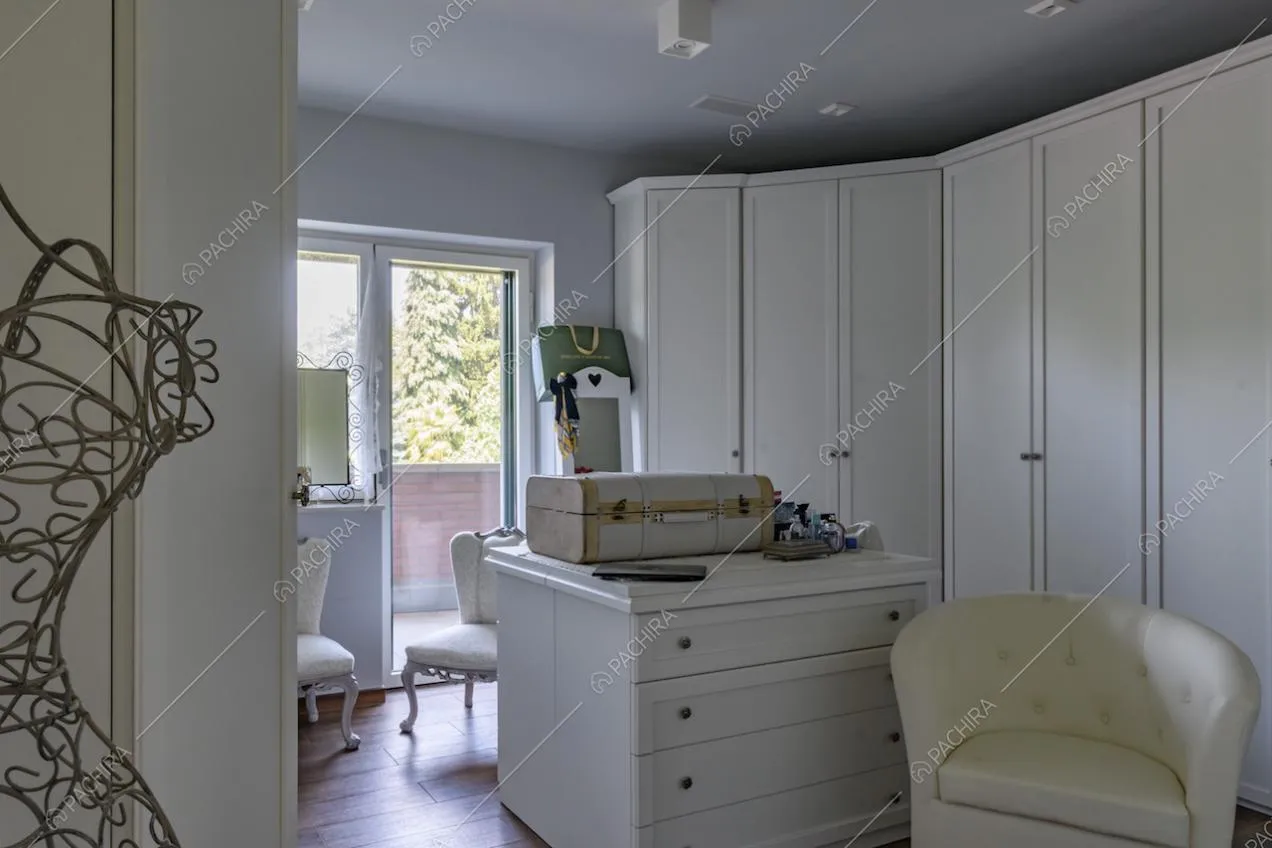 Ampia cabina armadio con pavimento in parquet e porta-finestra per accedere al balcone