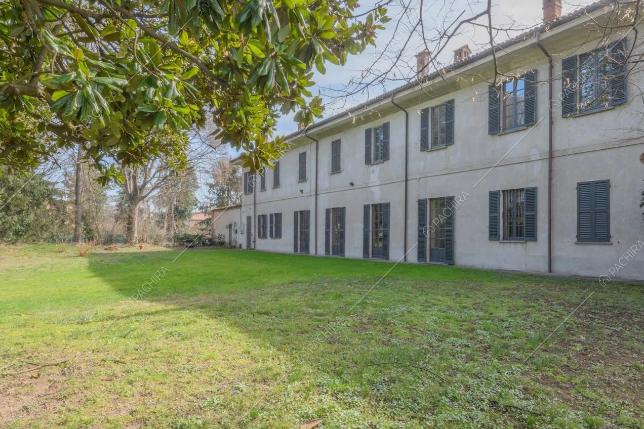 Giardino della dimora storica con vista sugli esterni bianchi con persiane