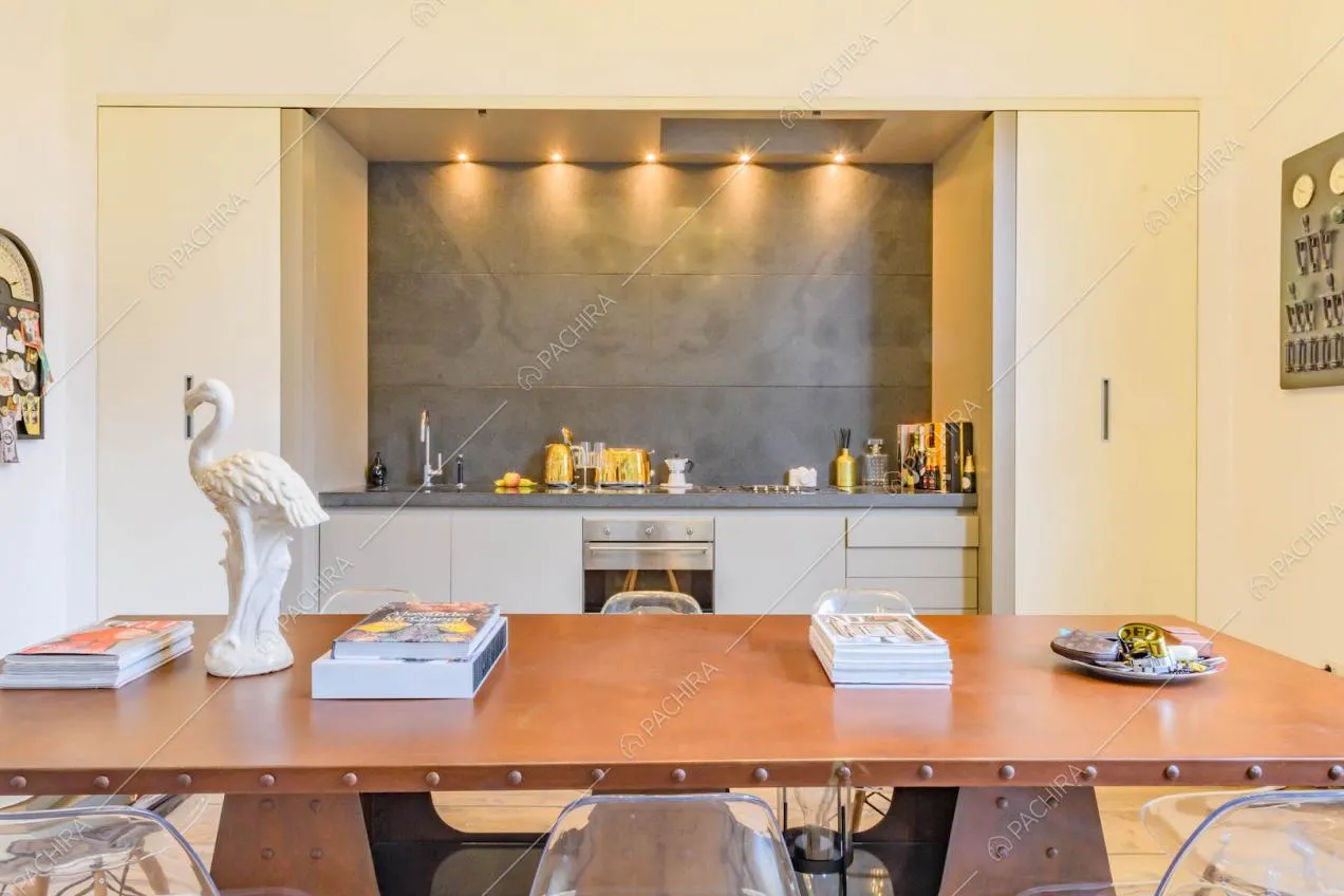 Tavolo da pranzo nella cucina con pavimento in parquet e parete grigia