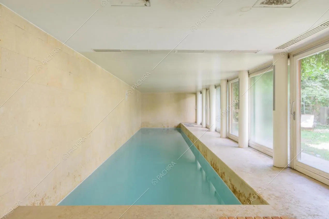Grande piscina coperta e vetrate scorrevoli