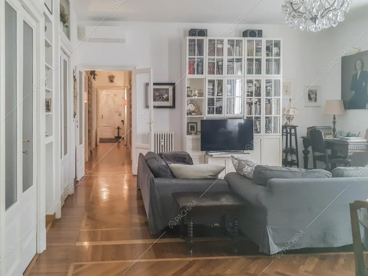 Arredi antichi, libreria, divani e parquet nel salotto