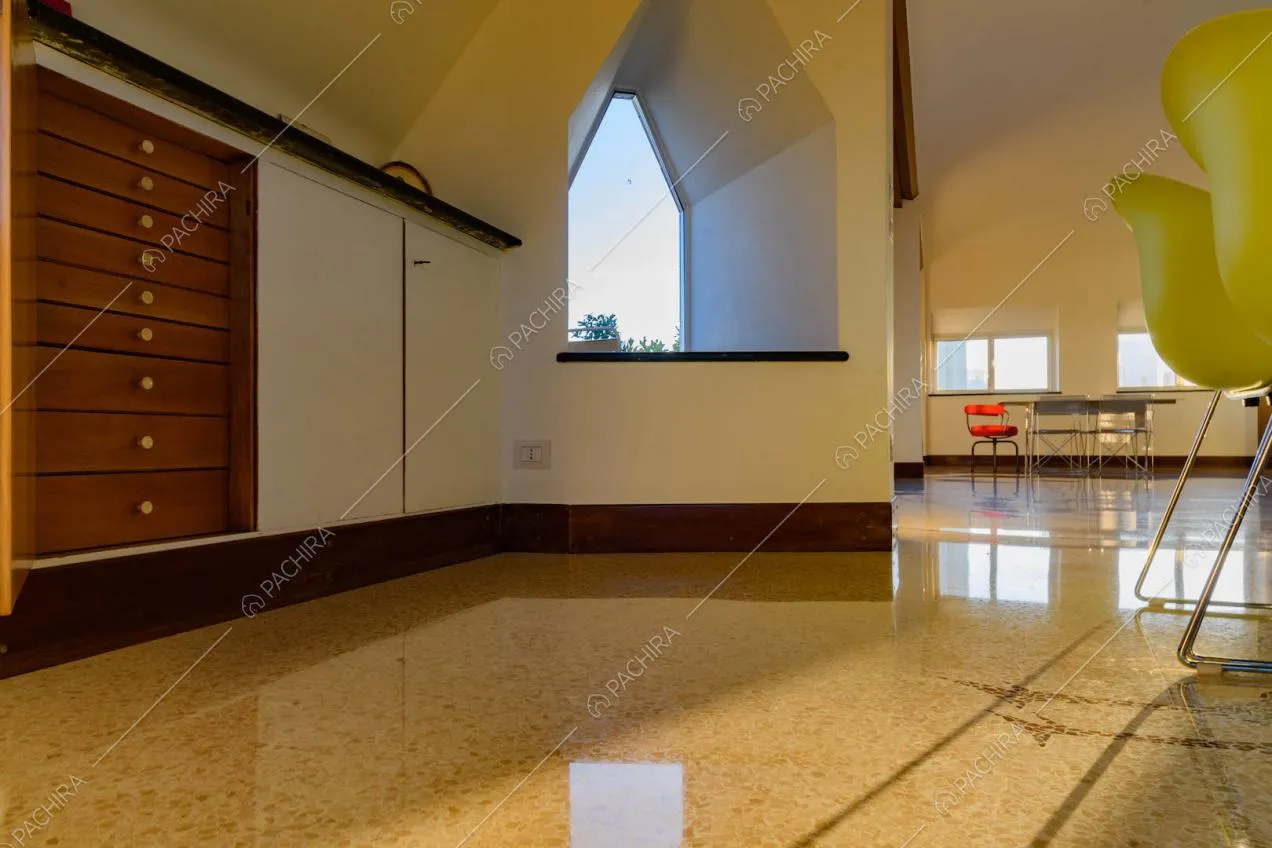 Pavimento in marmo nella grande sala con tavoli in metallo