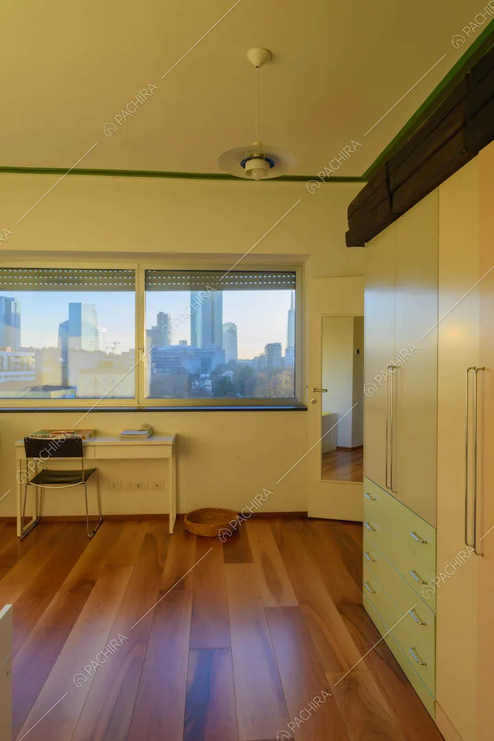 Pavimento in parquet e finestre con vista sullo skyline nella camera da letto