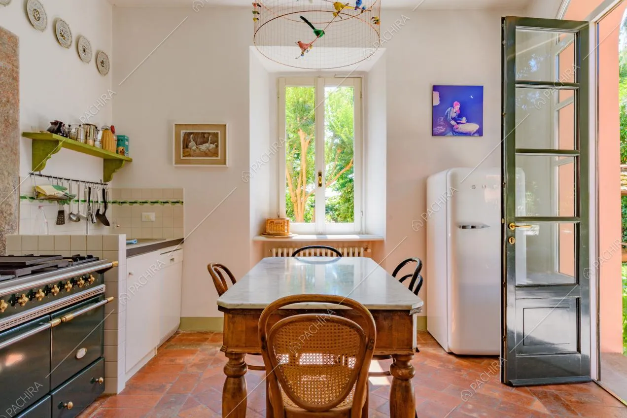Cucina con pavimento in cotto, fornelli a gas e tavolo da pranzo in legno