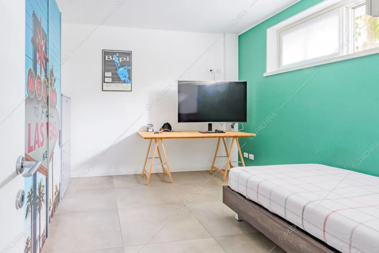 Camera con letto singolo, parete verde e armadio a muro