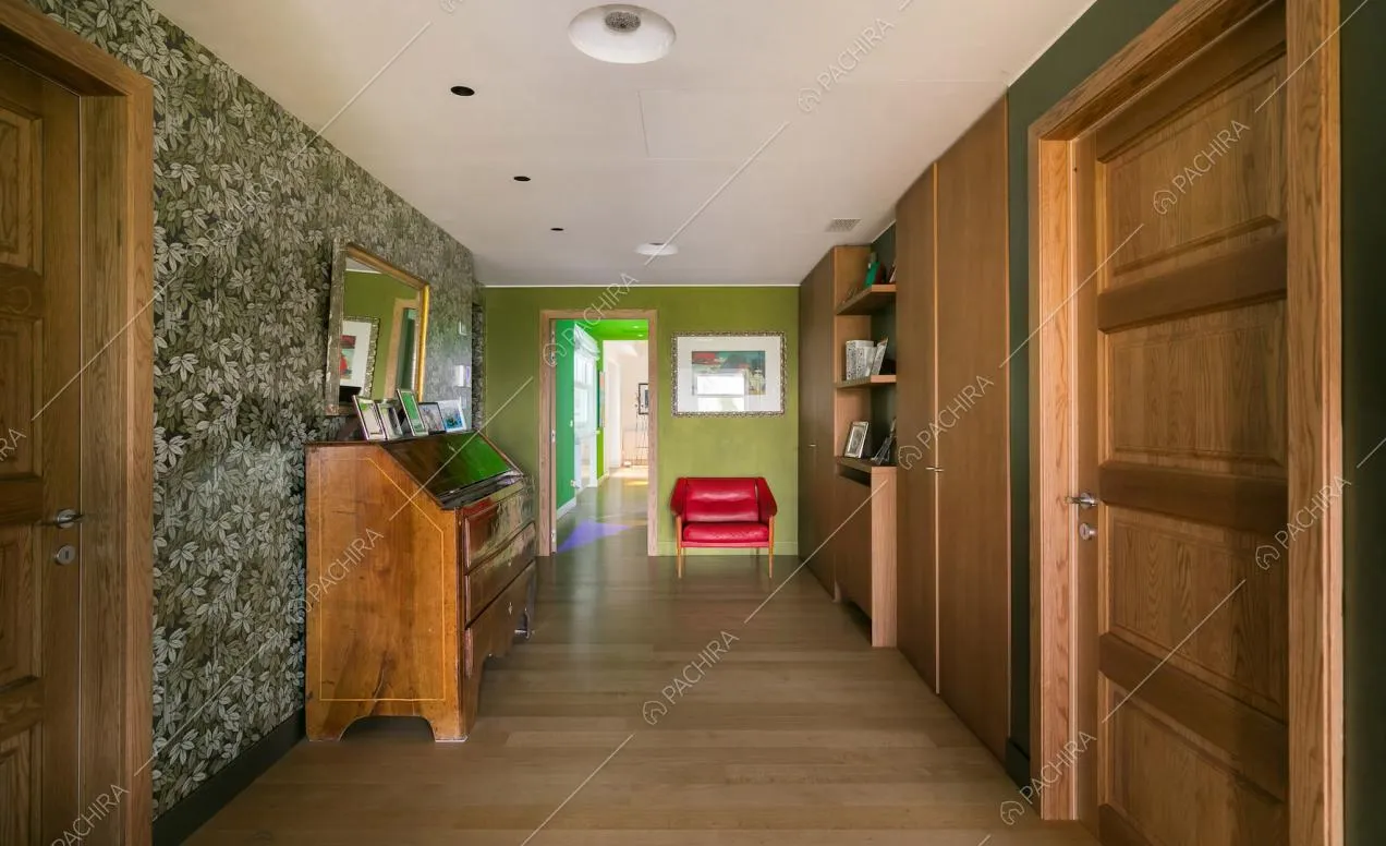 Corridoio con pavimento in parquet e carta da parati a tema floreale