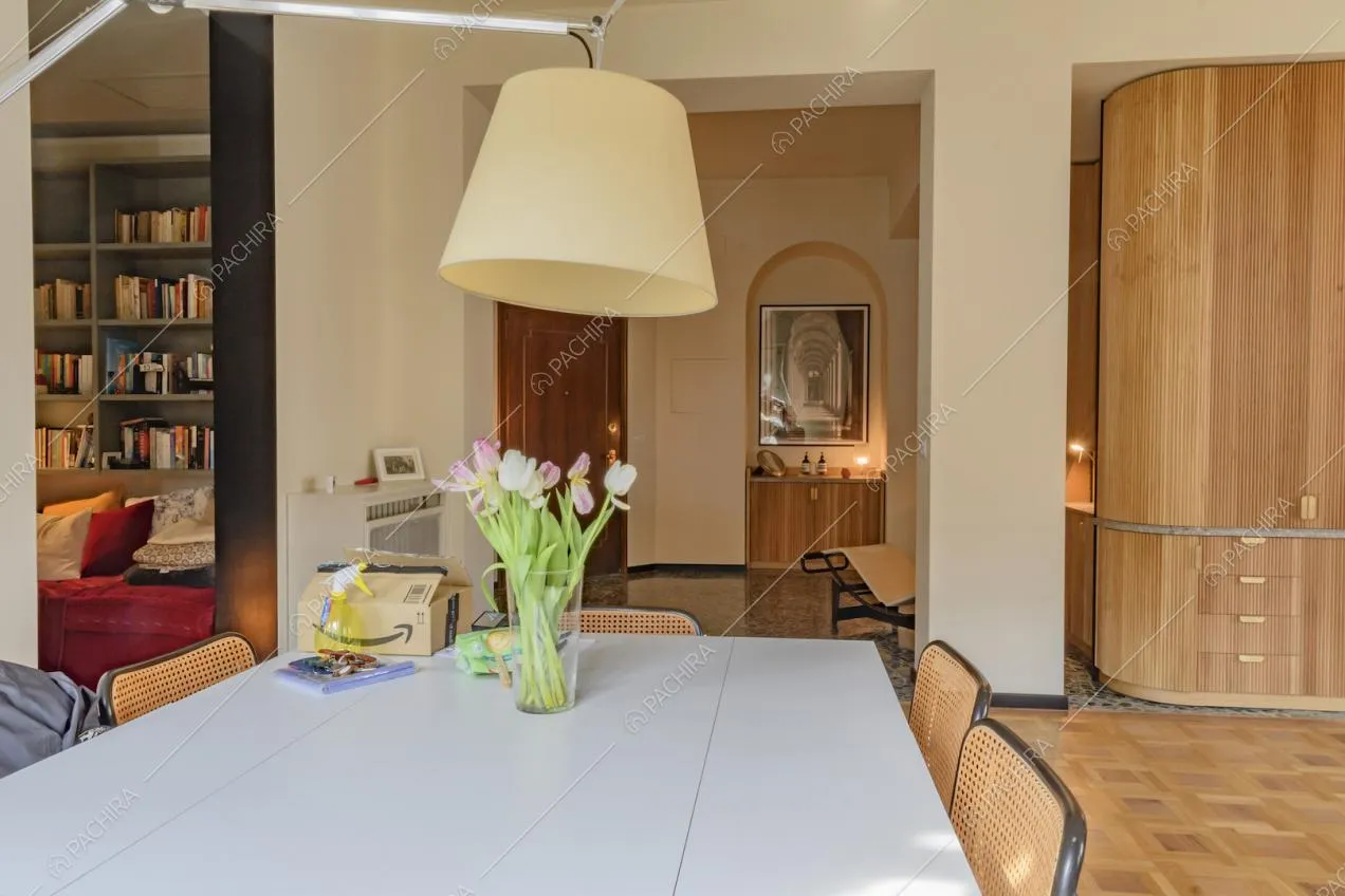 Tavolo da pranzo bianco e vita sul soggiorno e sul corridoio dalle pareti bianche