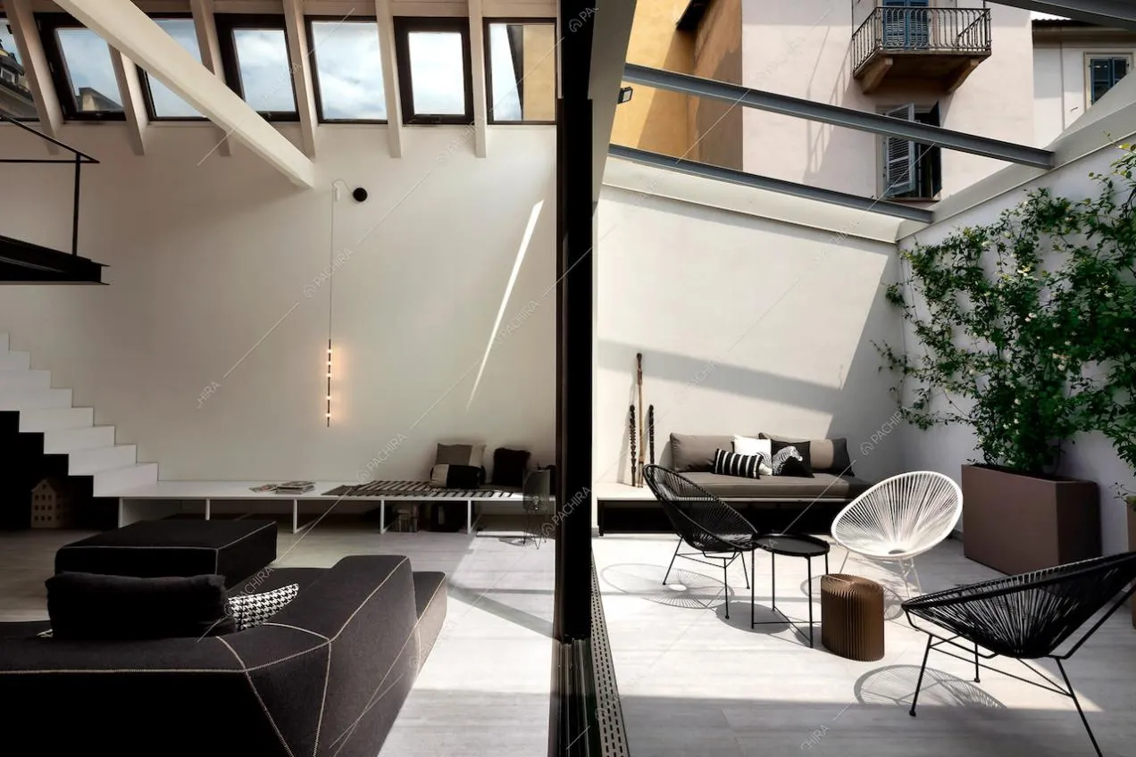 Divano nero con isola e giardino d'inverno con sedie di design da esterno