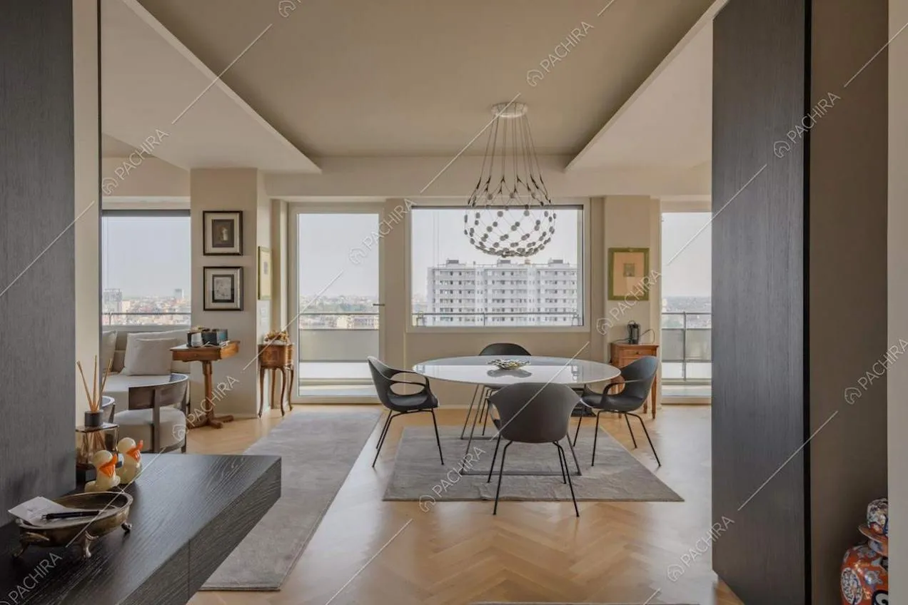 Pavimento in parquet a spina di pesce nella grande zona living con vetrate