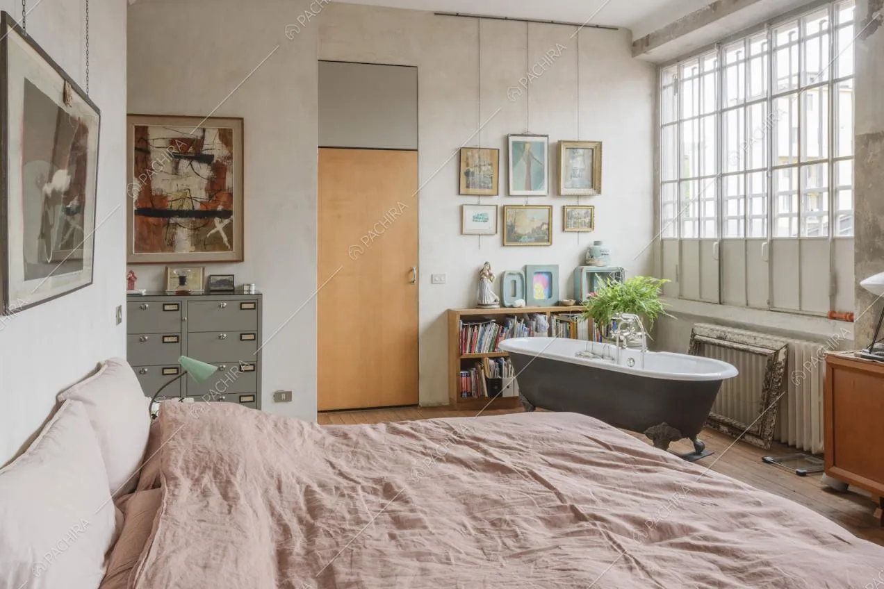 Camera da letto con quadri sulle pareti e luce naturale