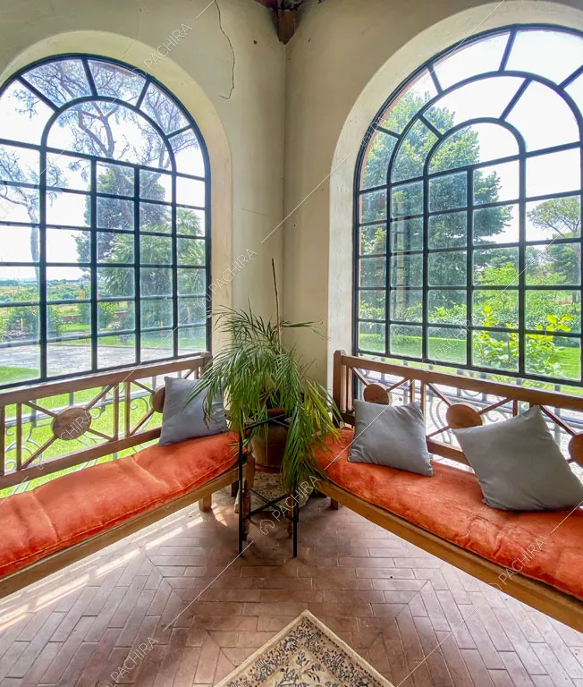 Panche nella stanza riempita di luce naturale dalle vetrate con vista sul giardino