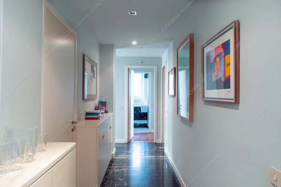 Dal corridoio con pavimento in piastrelle nere vista sul bagno