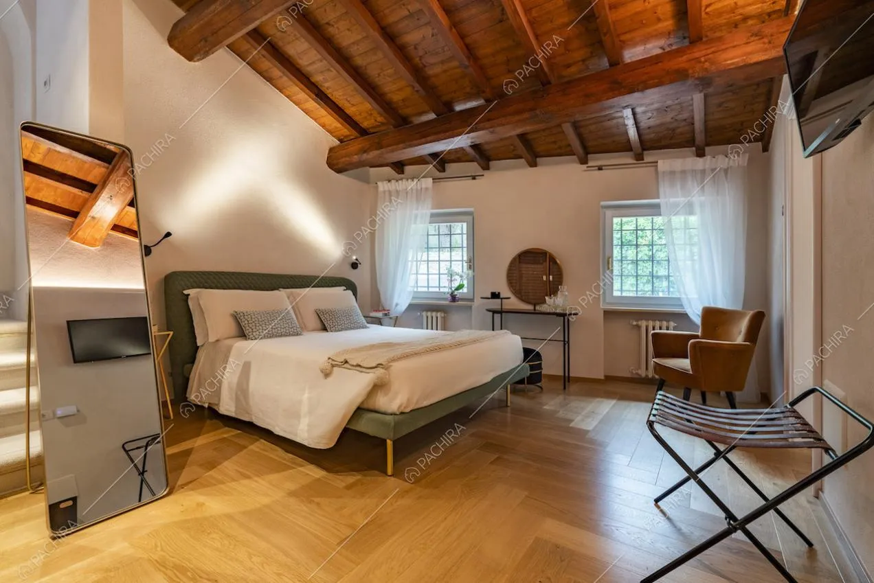 Camera da letto matrimoniale con specchio da terra e poltrona