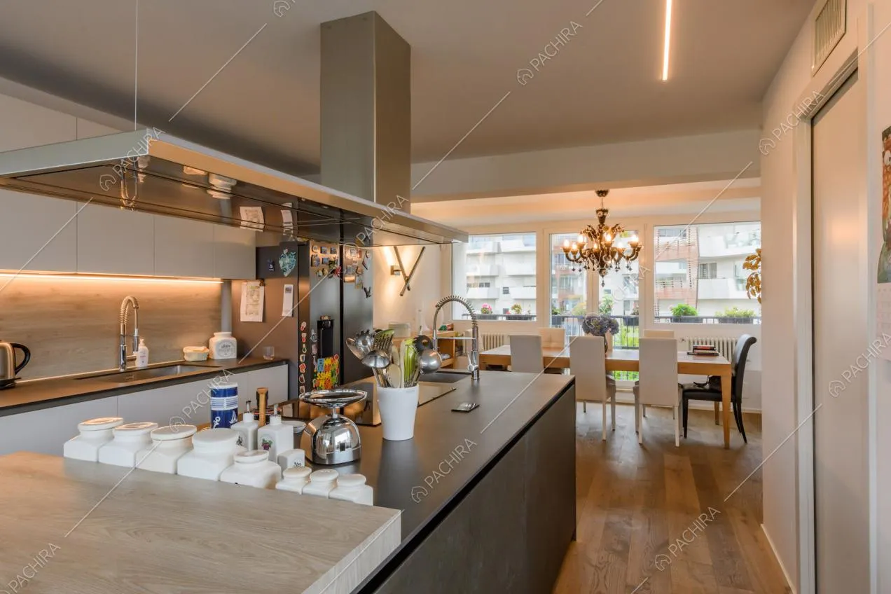 Isola nera della cucina con pavimento in parquet e vista sul tavolo da pranzo