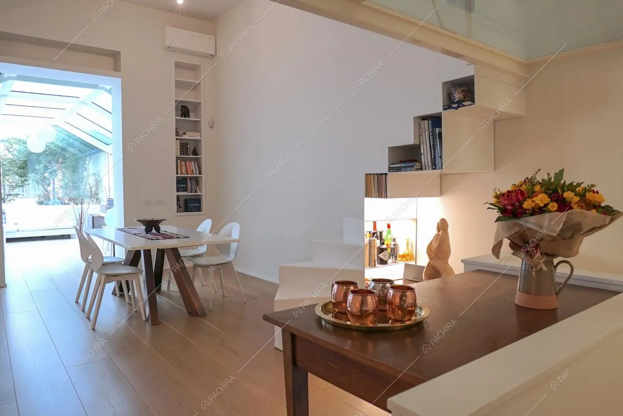 Tavolo da pranzo moderno con sedie bianche e parquet