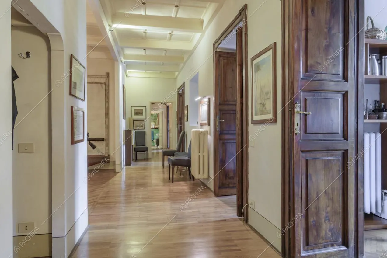 Porte in legno e quadri lungo le pareti del corridoio