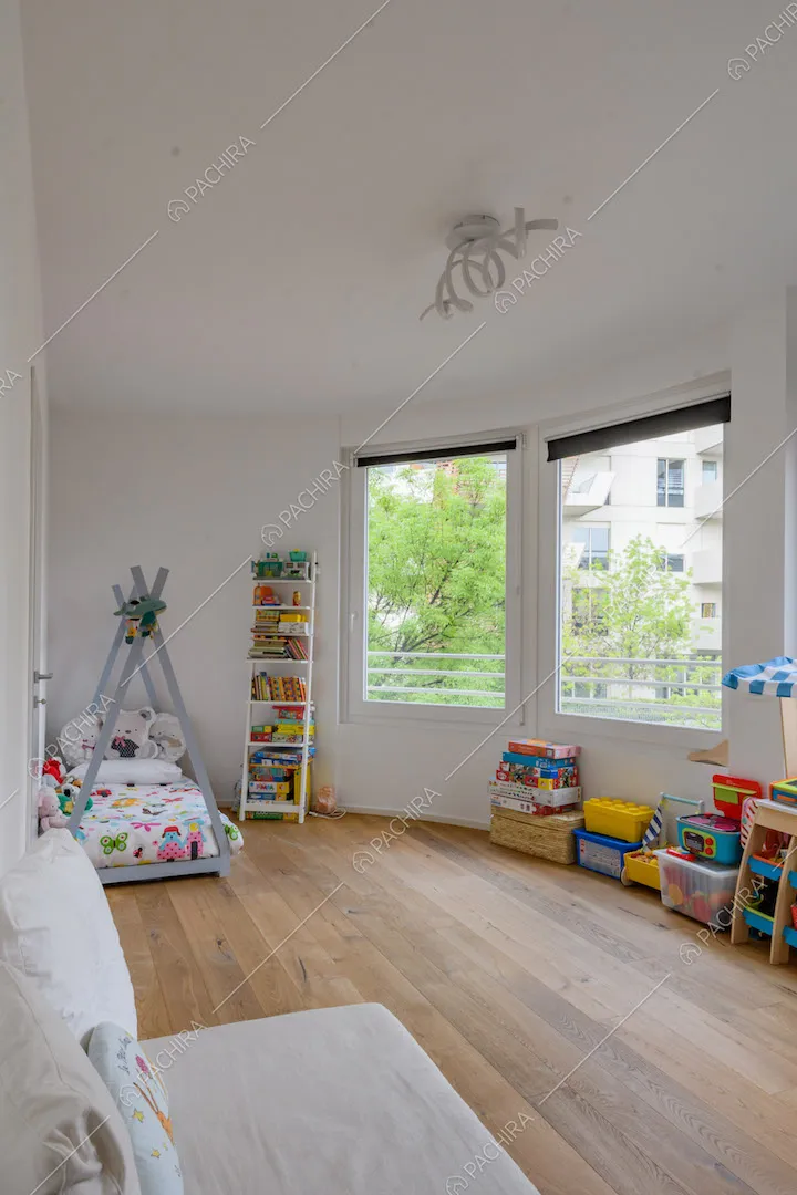 Camera dei bambini con pavimento in parquet e vetrate