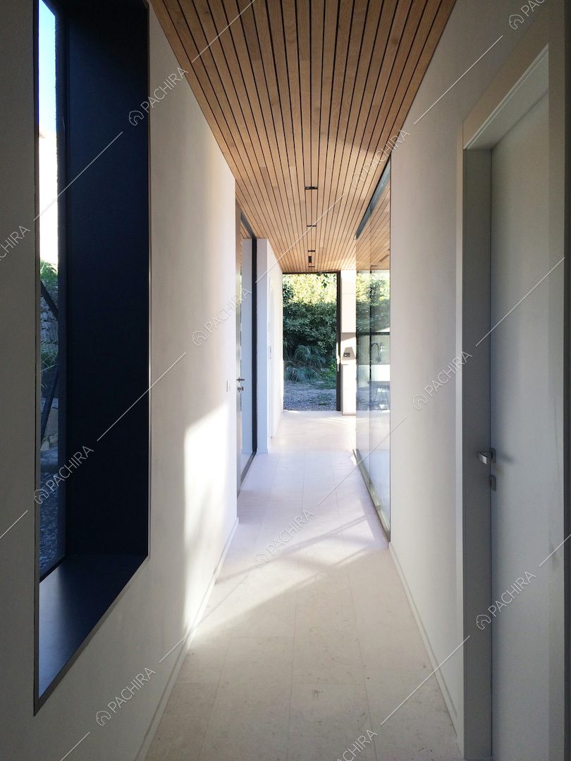 Corridoio della location con pareti e pavimento bianchi e soffitto in legno