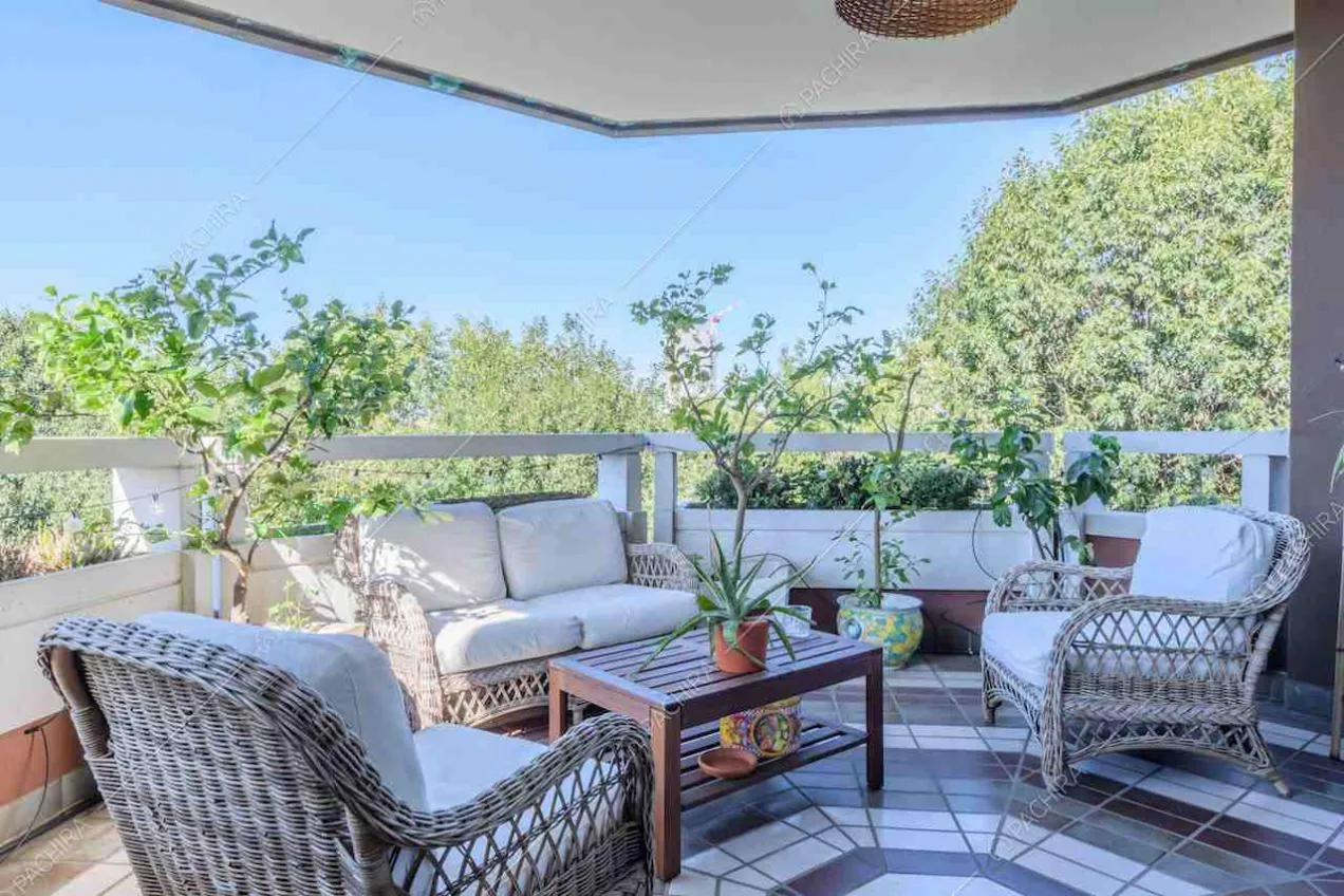 Poltrone e divano in vimini sulla terrazza coperta