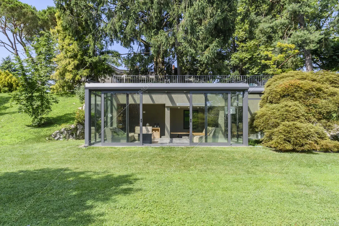 Serra moderna con vetrate immersa nel verde