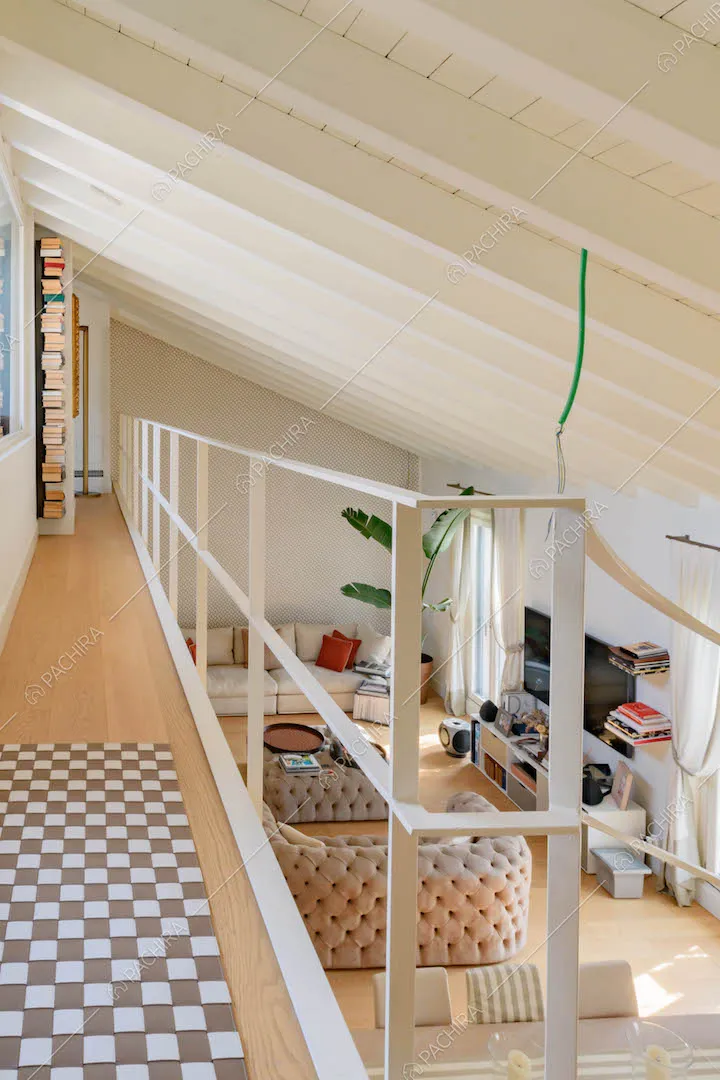 Ringhiera bianca sul soppalco con pavimento in parquet e soffitto in travi bianche a vista