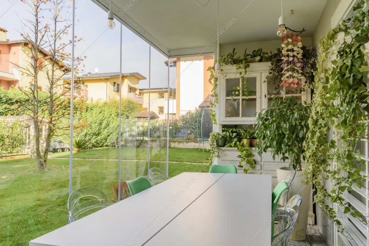 Tavolo da pranzo sito nella veranda con piante pendenti