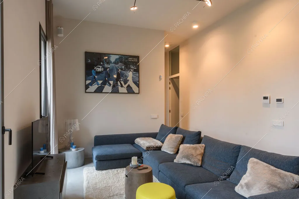 Divano blu nella sala dell'appartamento Fiore di porro, location in stile minimal a Monza