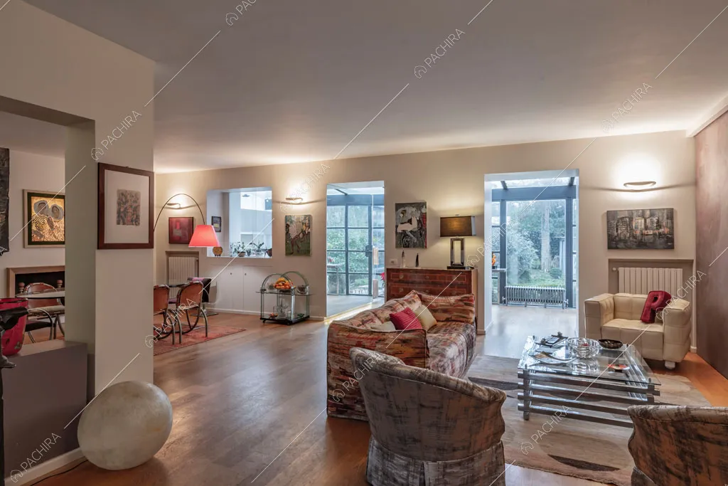 Zona living con vista sulle vetrate della cucina dell'appartamento Catalpa, location in stile moderno a Roma