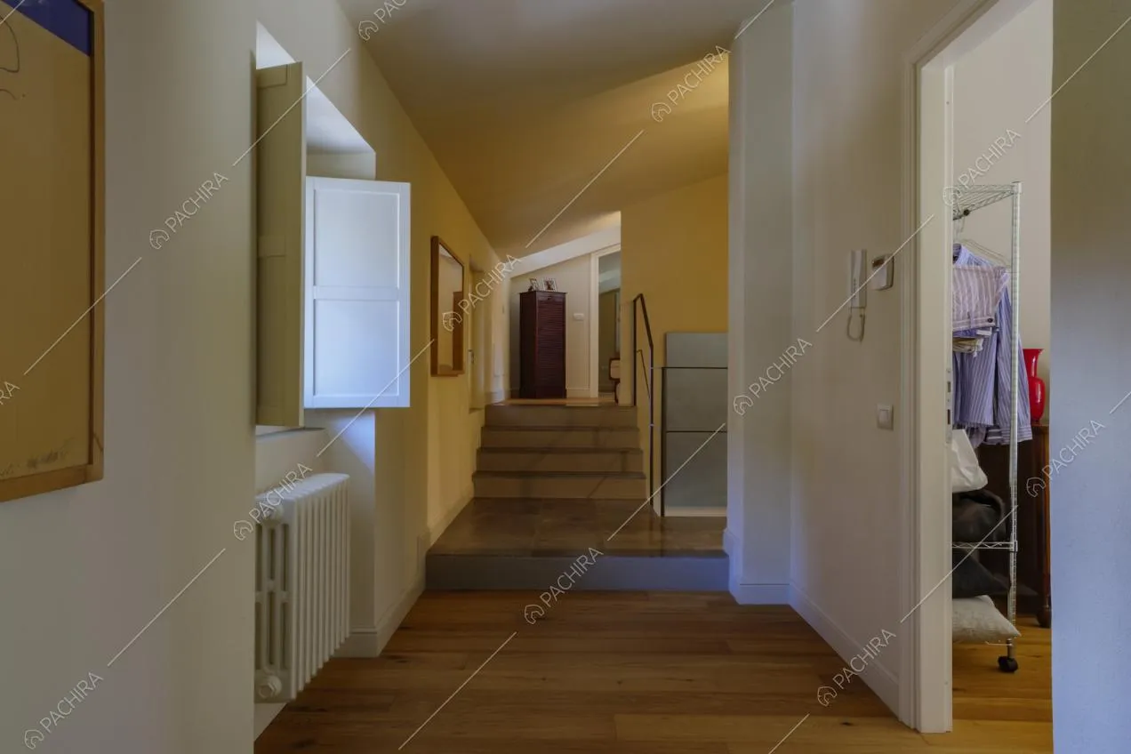 Corridoio con pavimento in parquet, scale e scorcio sulla cabina armadio