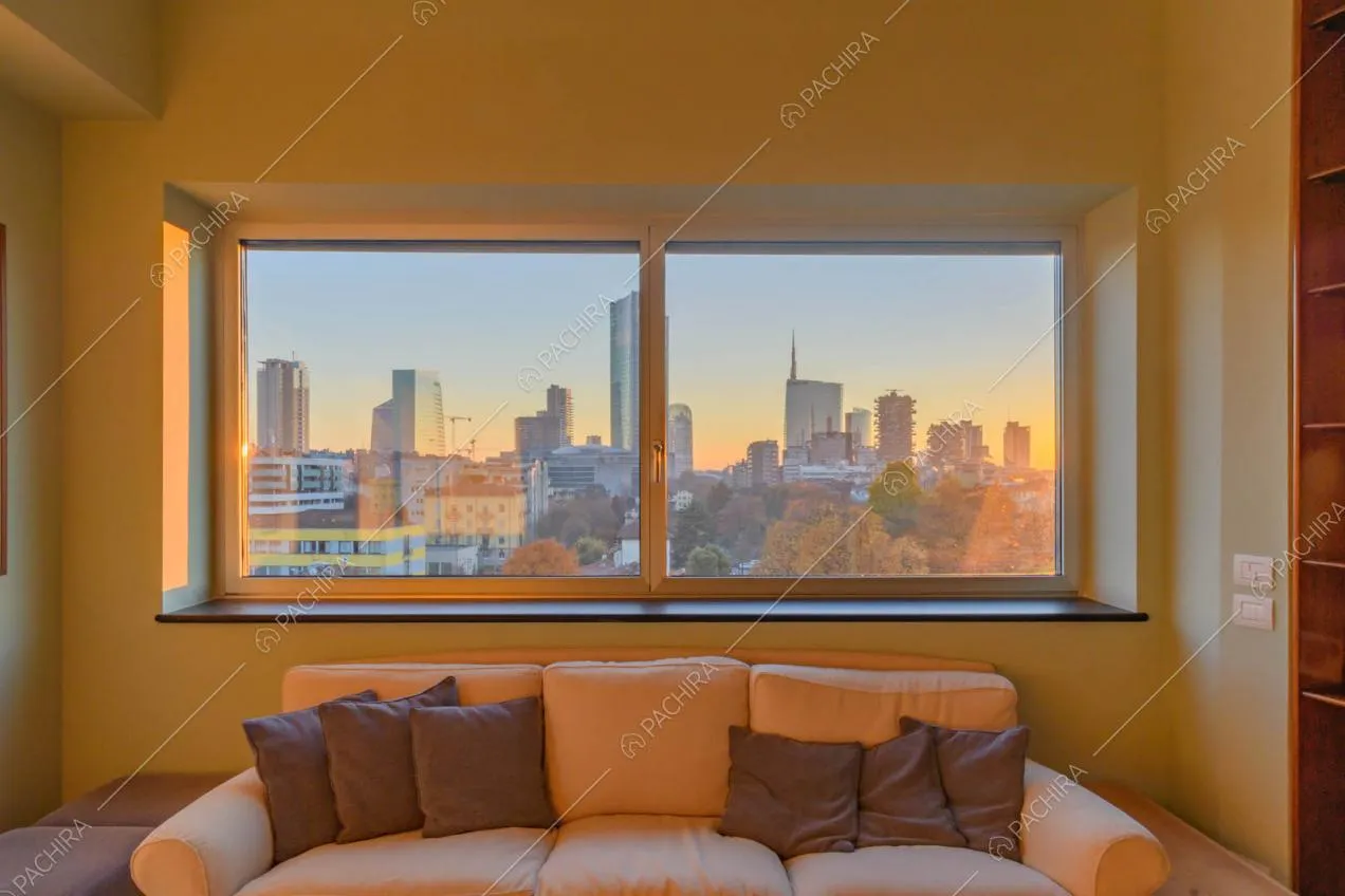 Luminoso salotto con divano bianco e vista sullo skyline