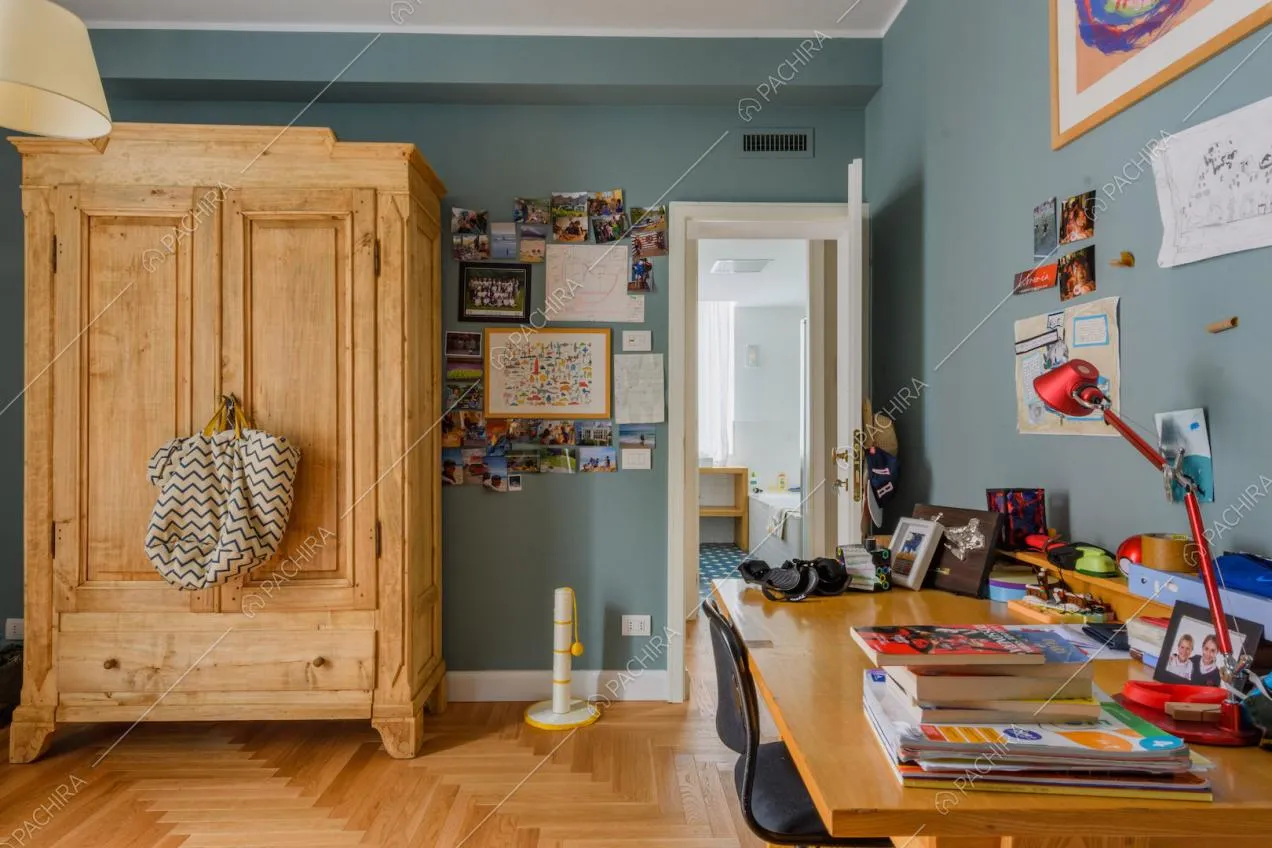 Camera da letto con pavimento in parquet, scrivania e vista sul bagno con vasca