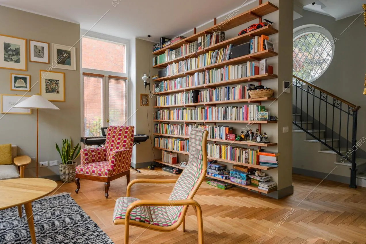 Dal salotto con pareti beige e pavimento in parquet a spina di pesce vista sulle scale